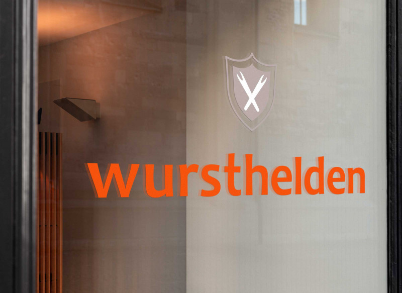 Logoschriftzug Wursthelden auf Fensterscheibe